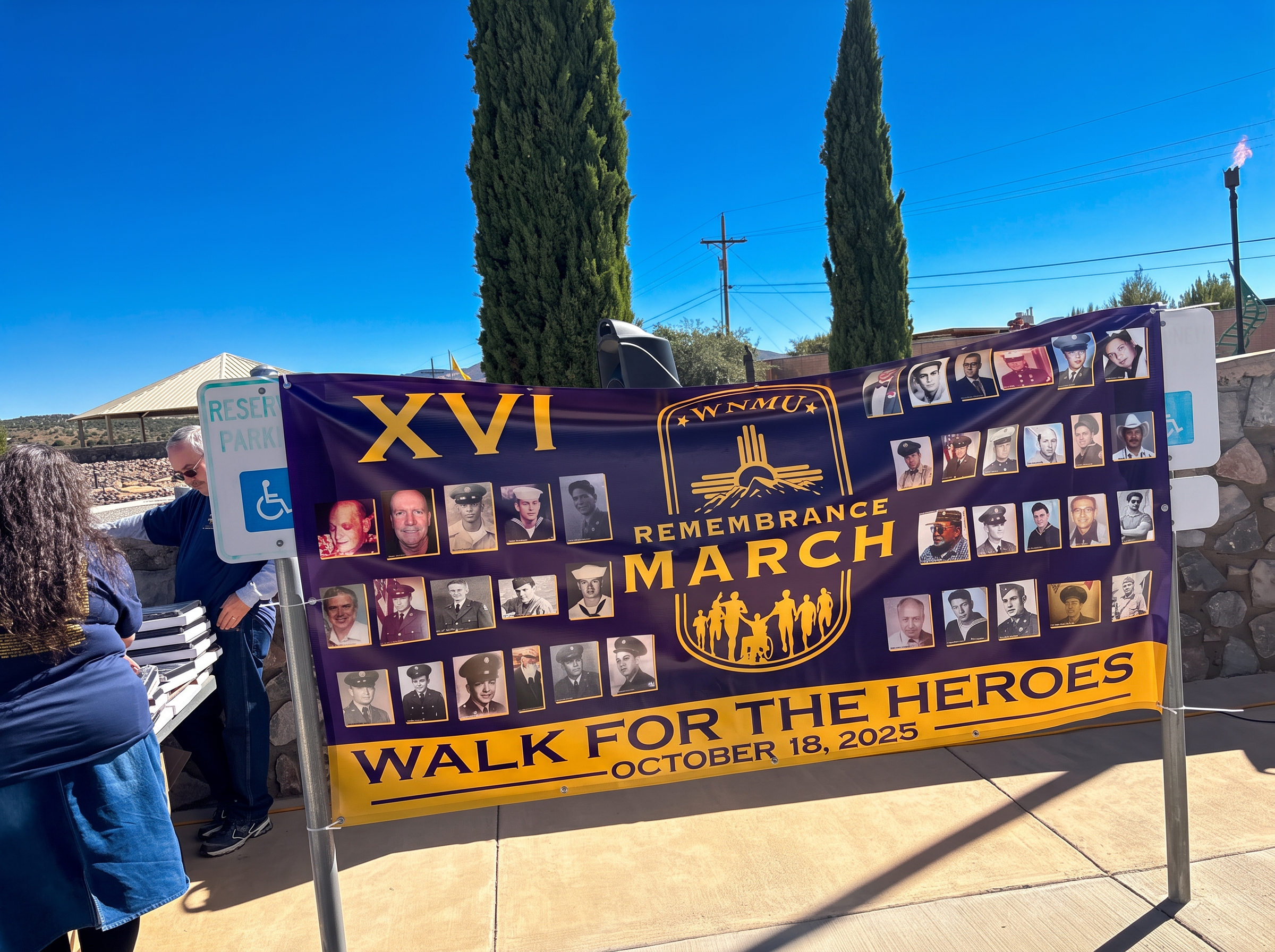 Walk for the Heroes remembrance march banner with photos of honored veterans